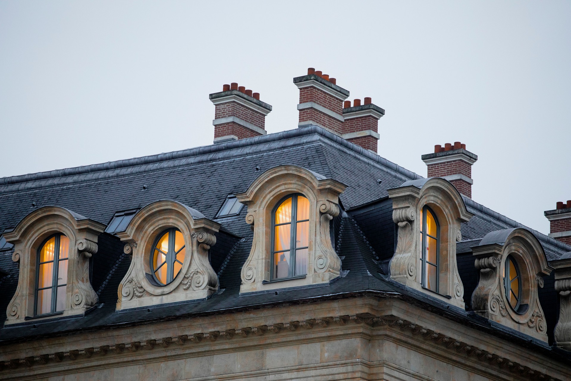 Lights on in the windows of a traditional Parisian building